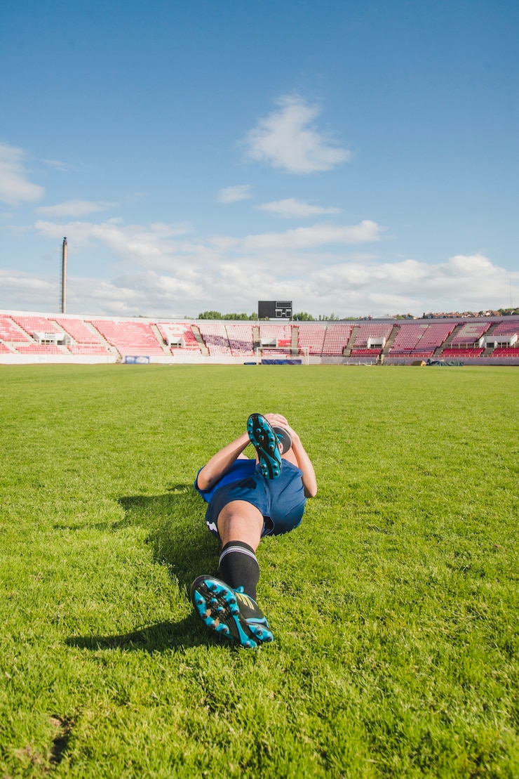 Photo gratuit joueur de football tendant les jambes