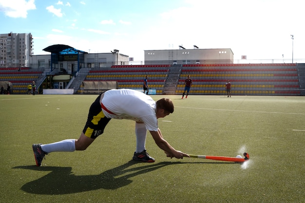 Joueur de hockey sur gazon en équipement sur l'herbe