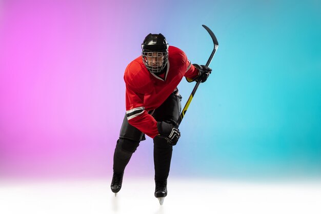 Joueur de hockey masculin avec le bâton sur la cour de glace