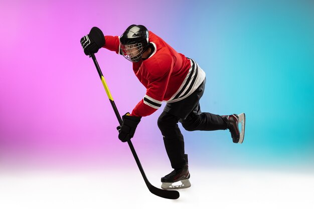 Photo gratuite joueur de hockey masculin avec le bâton sur le court de glace et le mur dégradé de couleur néon