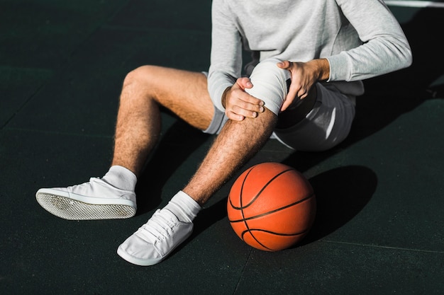 Joueur méconnaissable appliquant un bandage sur le genou