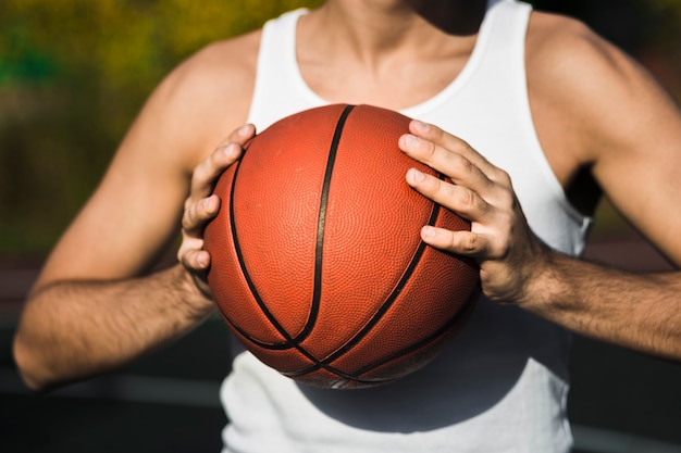 Joueur méconnaissable tenant un ballon de basket