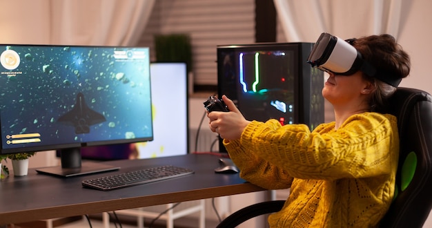 Un joueur professionnel de cyber-sport se détend en jouant à des jeux vidéo à l'aide d'un jeu de tir virtuel de fin de soirée avec un casque vr ...