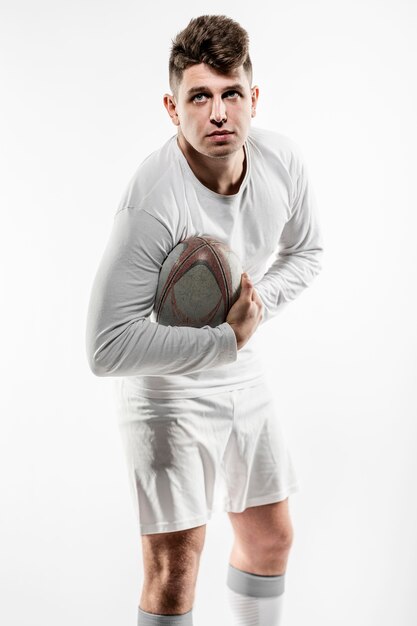 Joueur de rugby masculin posant avec ballon