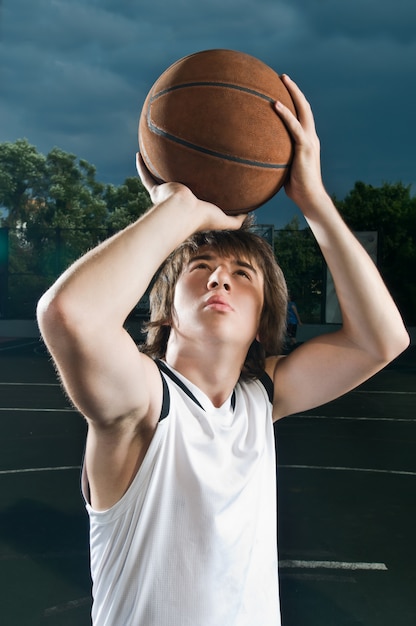 Le joueur de Streetball tirant du basketball