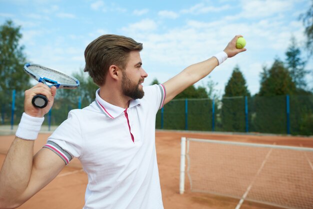 Le joueur de tennis attrape une balle de tennis