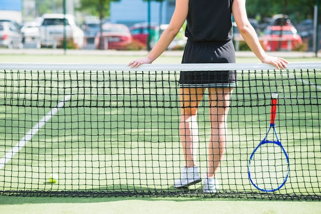 Joueur de tennis avec une raquette debout derrière le filet