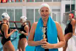 Photo gratuite joueur de water-polo à la piscine avec trophée