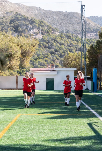 Photo gratuite joueurs de football de tir complet en cours d'exécution sur le terrain