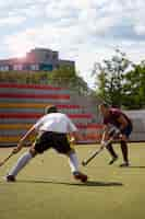 Photo gratuite joueurs de hockey lors d'un match sur l'herbe