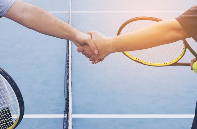 Joueurs de tennis serrant la main avant le match sur un court de tennis