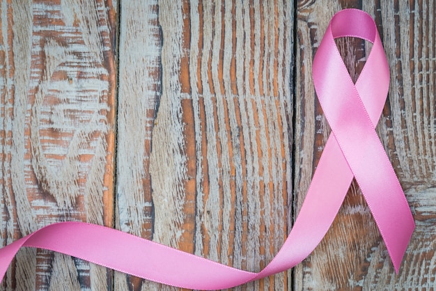 Photo gratuite jour du cancer du monde: breast cancer awareness ribbon sur bois backgr