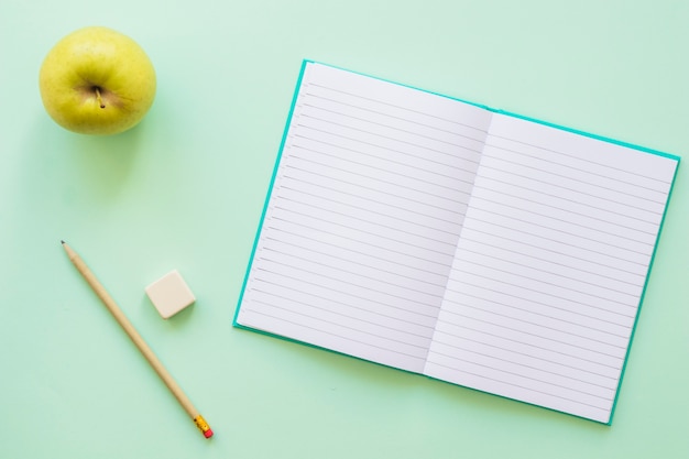 Journal ouvert avec un crayon aux pommes et du caoutchouc