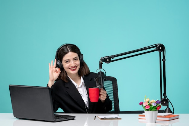 Journaliste blogueuse adorable jeune fille en blazer noir enregistrant un discours à la caméra tenant une tasse rouge