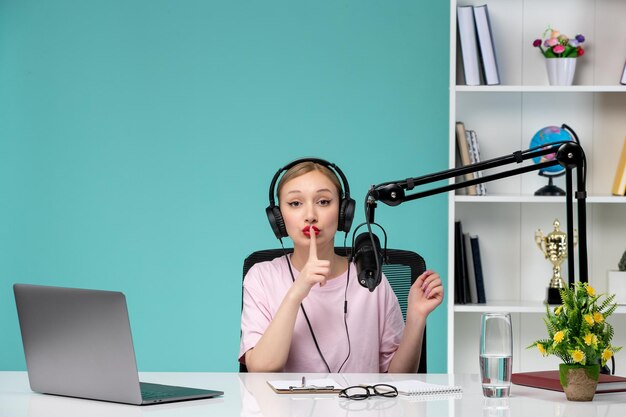 Journaliste blogueuse jolie fille blonde mignonne enregistrant une vidéo sur un ordinateur montrant le silence