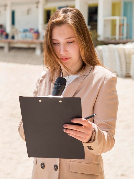 Photo gratuite journaliste femme debout sur la plage