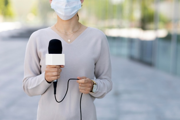 Journaliste avec masque médical