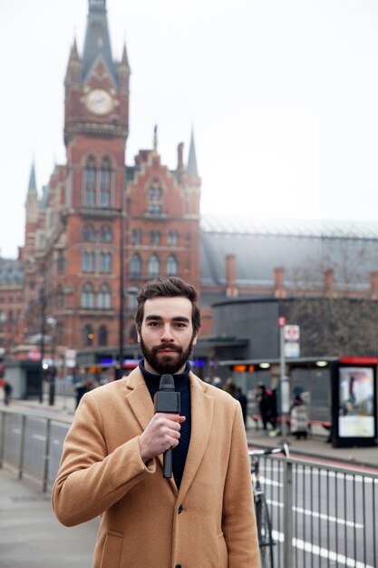 Journaliste de plan moyen avec microphone