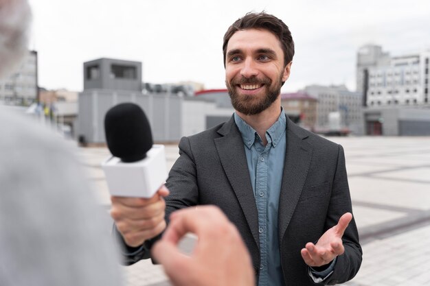 Journaliste prenant une interview d'un homme