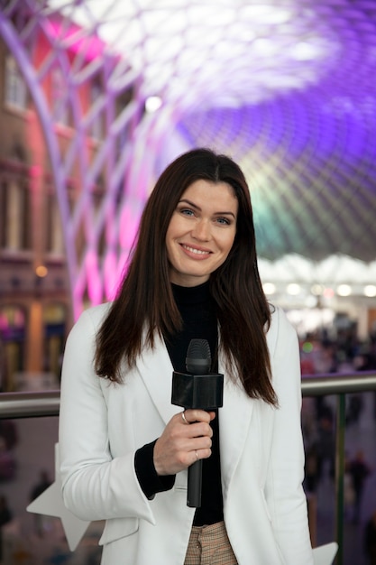 Journaliste souriant à coup moyen avec microphone