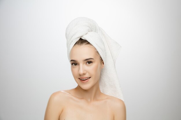 Journée de la beauté. Femme portant une serviette isolée sur fond de studio blanc. Journée de soins personnels, de soins de la peau, de routine beauté.