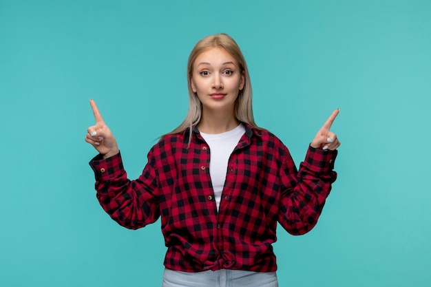 Journée internationale des étudiants jolie dame mignonne en chemise à carreaux rouge heureuse pointant les doigts vers le haut