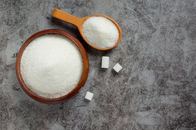 Journée mondiale du diabète; sucre dans un bol en bois sur fond sombre