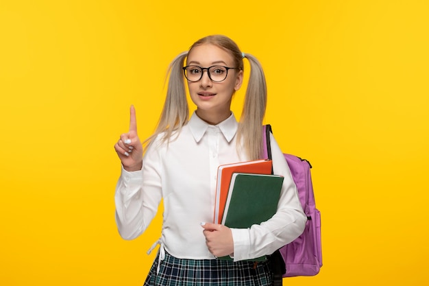 Journée mondiale du livre fille blonde souriante tenant des livres verts et rouges