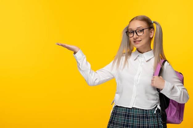 Journée mondiale du livre jeune écolière blonde en agitant les mains en uniforme