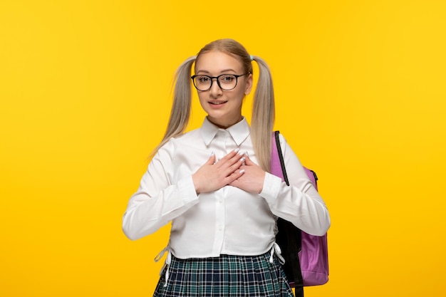 Journée mondiale du livre souriante écolière mignonne heureuse en uniforme tenant les mains ensemble