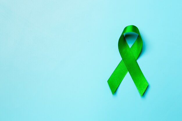 Journée mondiale de la santé mentale. ruban vert sur fond bleu