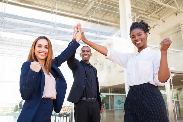 Photo gratuite joyeuse équipe de jeunes entrepreneurs satisfaits du lancement du projet