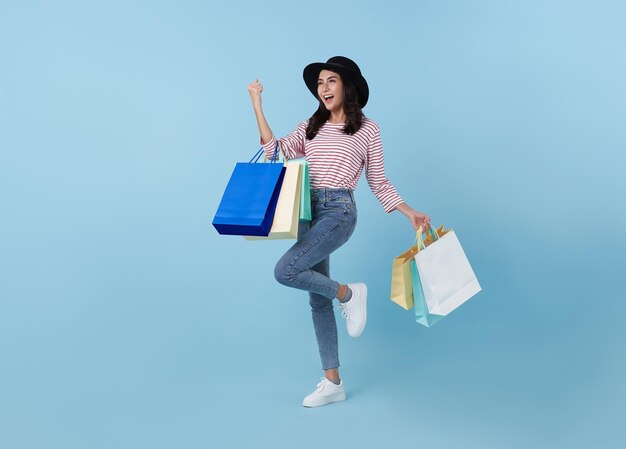 Joyeuse femme asiatique thaïlandaise heureuse appréciant le shopping, elle porte des sacs à provisions et la célébration