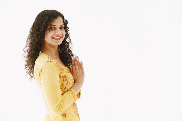 Joyeuse femme indienne traditionnelle sur fond blanc. Prise de vue en studio.