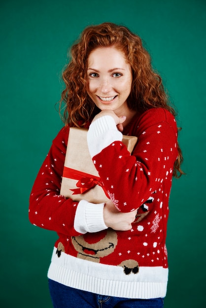 Joyeuse fille embrassant le cadeau de Noël