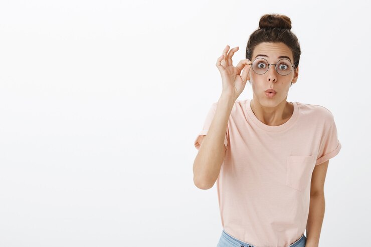 Photo gratuit joyeuse fille avec des lunettes posant contre le mur blanc