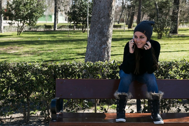 Photo gratuite joyeuse fille parlant au téléphone dans le parc