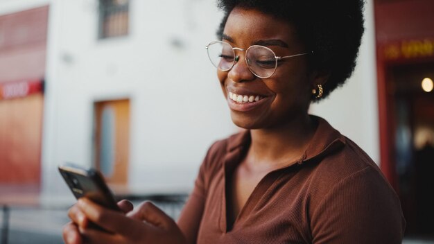 Joyeuse fille à la peau sombre souriant sincèrement en lisant un tex