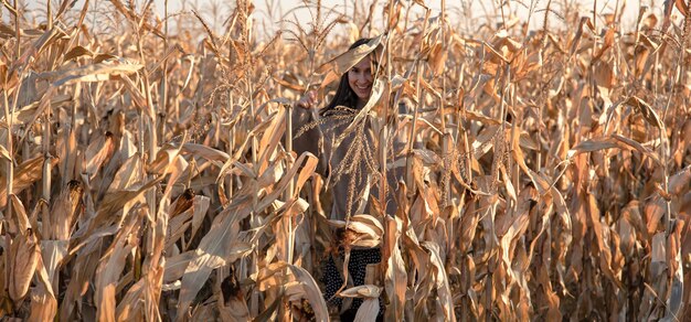 Joyeuse jeune femme dans un champ de maïs en automne.