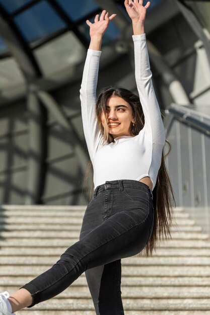 Joyeuse jeune femme dansant dans la rue