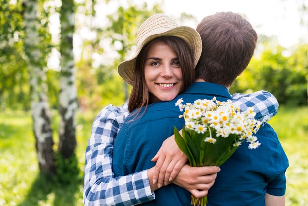 Joyeuse jeune femme embrassant son petit ami dans le parc