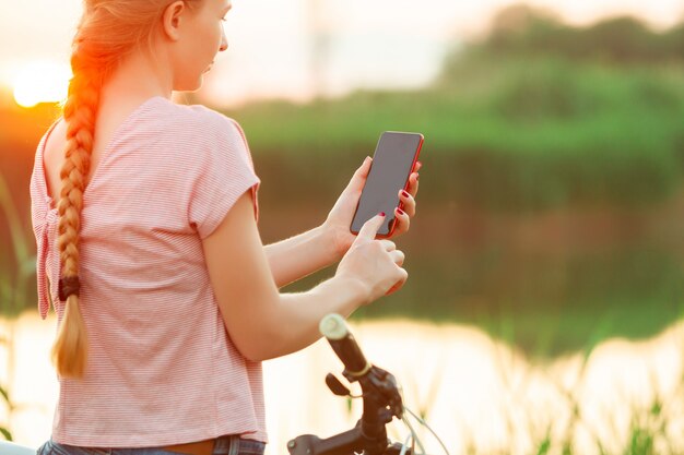 Joyeuse jeune femme, faire du vélo au bord de la rivière et promenade des prés