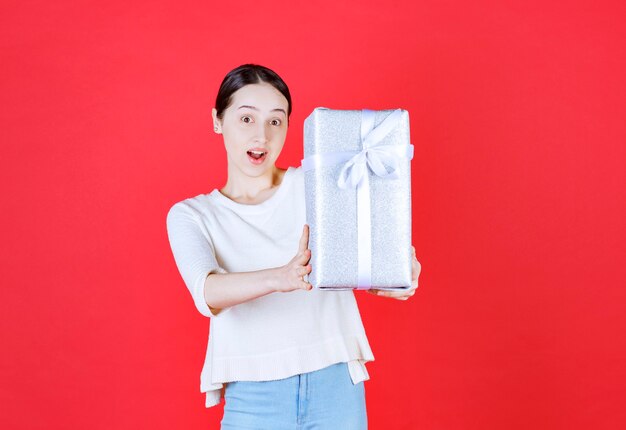 Joyeuse jeune femme tenant une boîte-cadeau