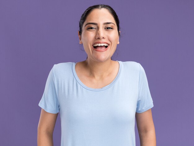 Joyeuse jeune fille caucasienne brune isolée sur un mur violet avec espace de copie