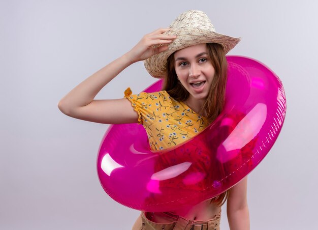 Joyeuse jeune fille portant chapeau et anneau de bain mettant la main sur le chapeau sur un espace blanc isolé