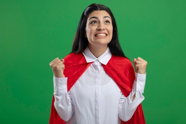 Joyeuse jeune fille de super-héros de race blanche à la recherche de faire oui geste isolé sur fond vert avec espace de copie