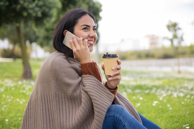 Joyeuse jolie fille ayant une conversation téléphonique agréable