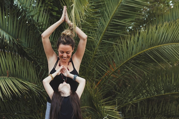 Photo gratuite joyeuse mère et fille debout dans la pose d'arbre