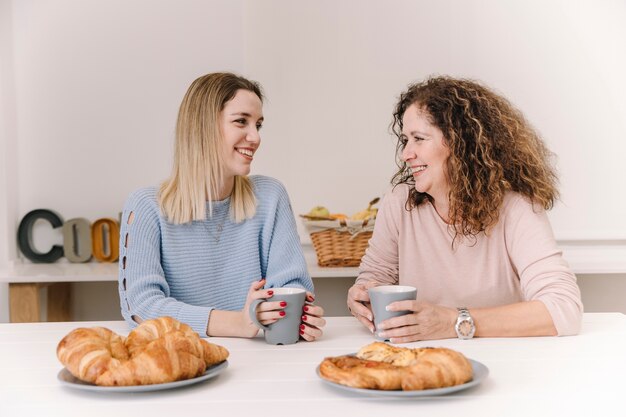 Joyeuse mère et fille prenant son petit déjeuner