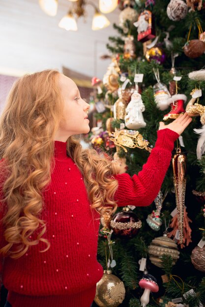 Joyeuse petite fille à la recherche de décoration pour la maison et de cadeaux de vacances dans un magasin ménager